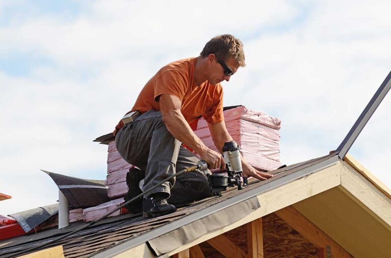 Snow-covered residential roof displaying slate, metal, and tile roofing materials in winter conditions.